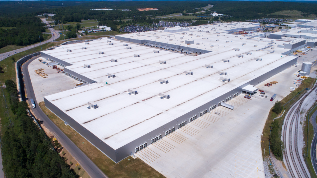 Expansive commercial warehouse with a white flat roof, showcasing modern industrial design.