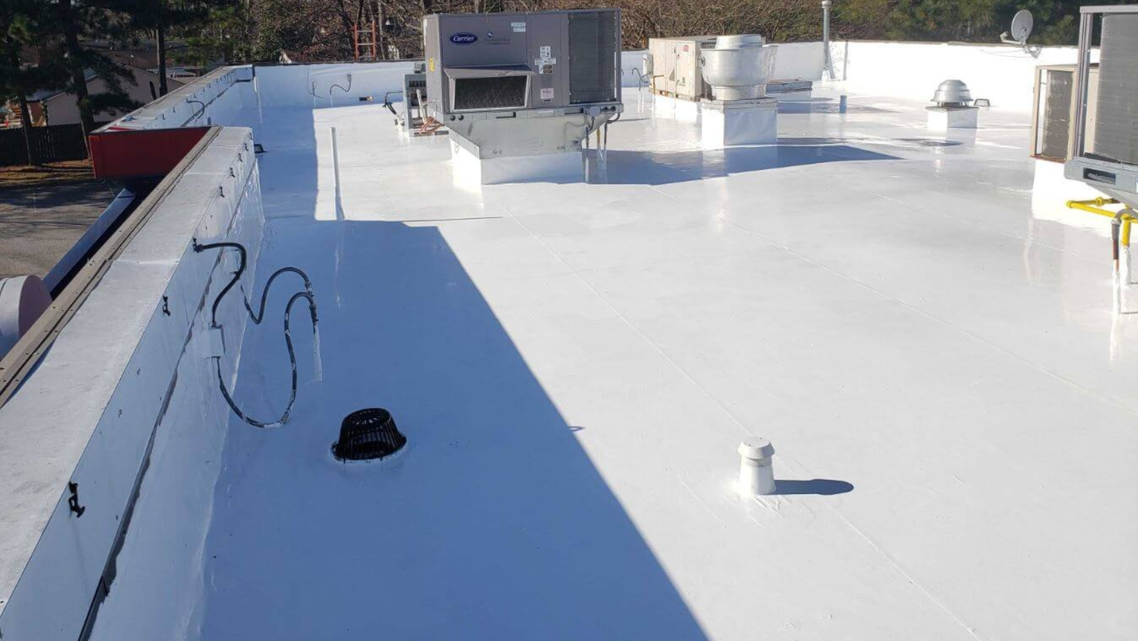 A freshly painted white roof, showcasing SmartSeal's efficient roof coating installation process.