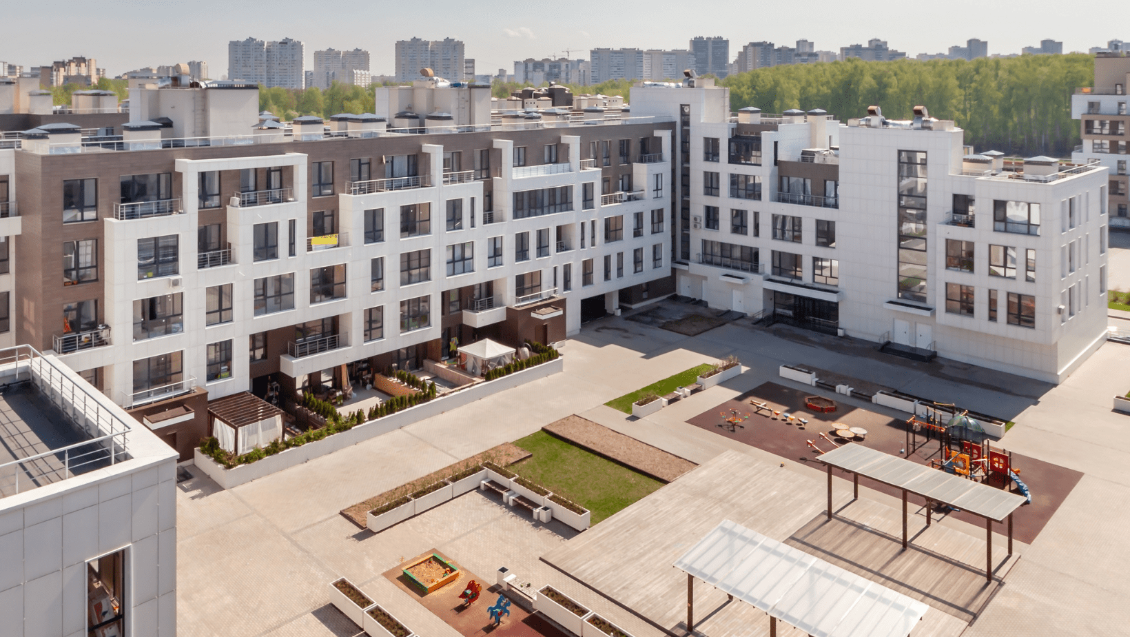 Aerial view showcasing a large apartment complex surrounded by greenery and pathways, highlighting its expansive layout.