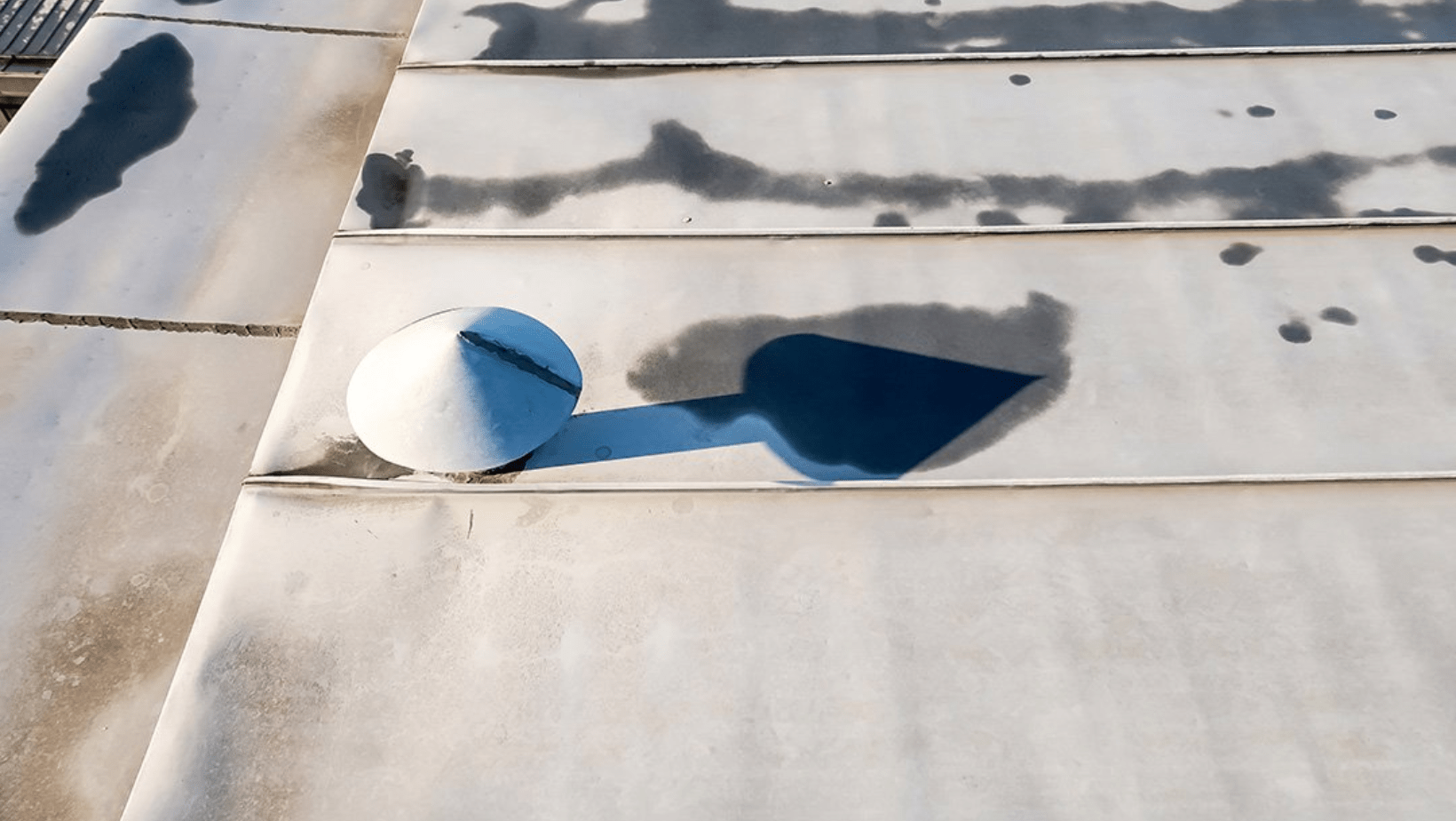 A white object on a roof, covered in water, indicating potential roof leaks and maintenance issues