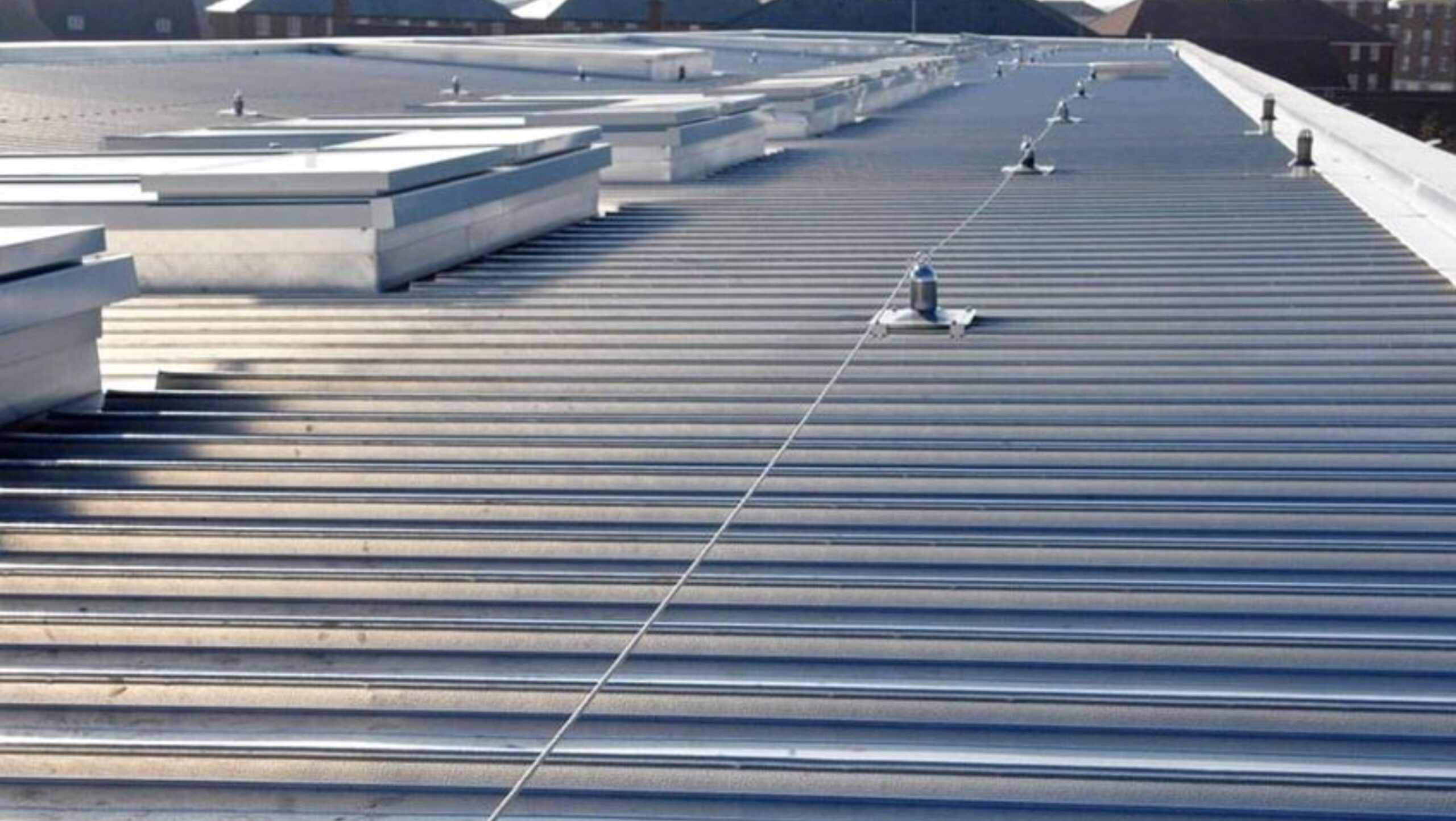 An overhead view of a roof with an intricate layout of metal pipes, highlighting industrial architecture.