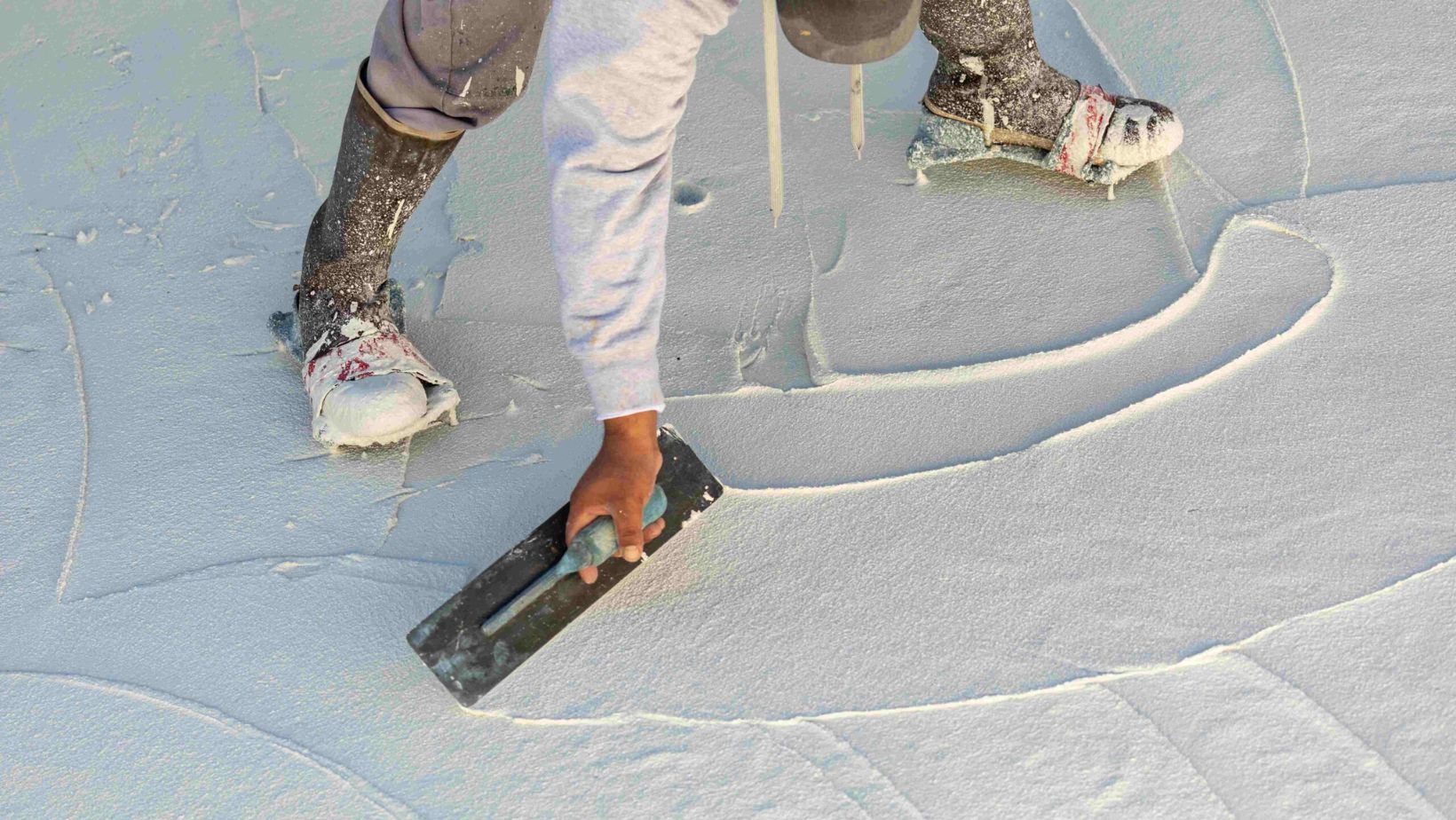 A person painting a white surface with a roller