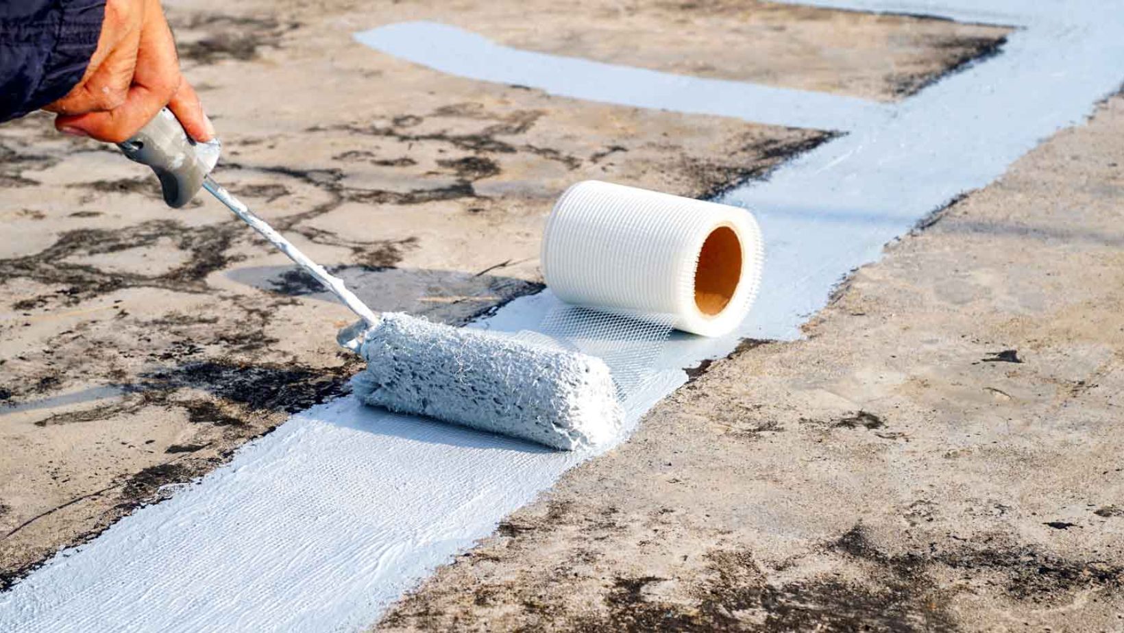 A person applies blue paint to a sidewalk