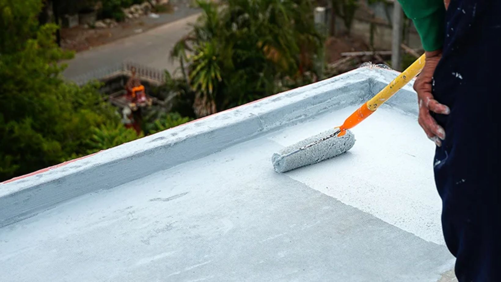 A man brushes debris off a roof