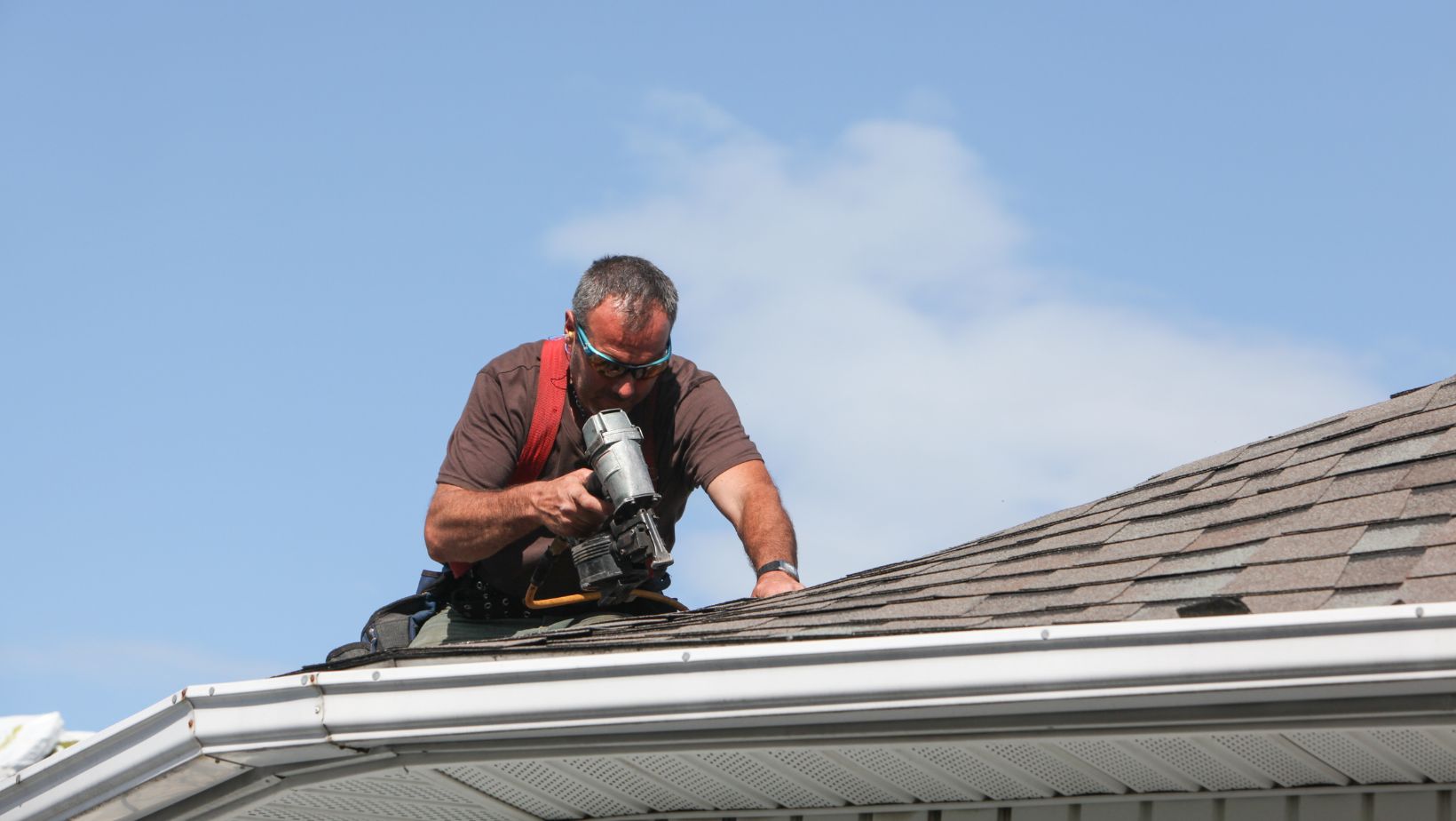 A man using a drill to work on a roof