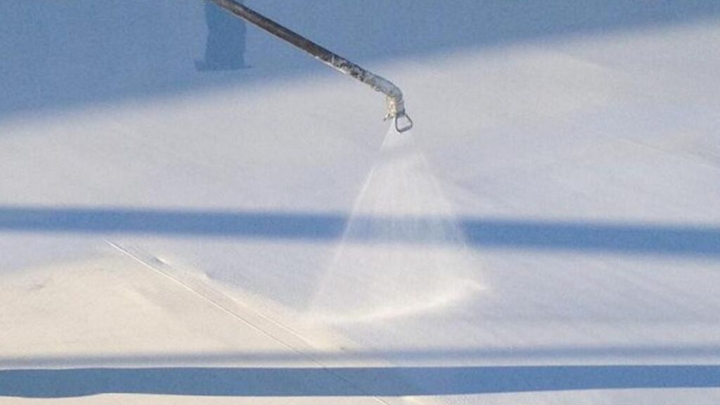 A person sprays water onto a roof