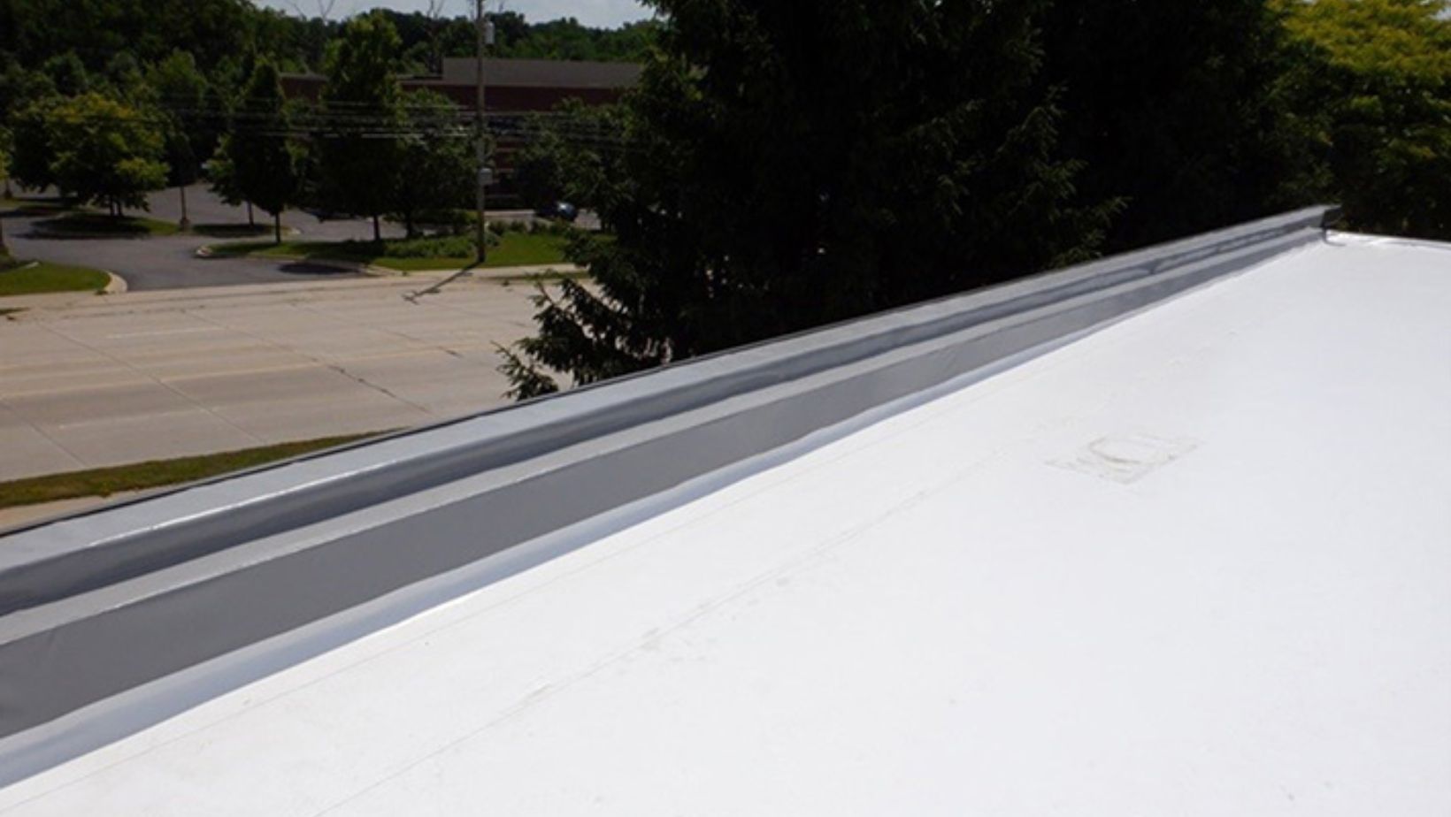 A white roof featuring a metal rail on top